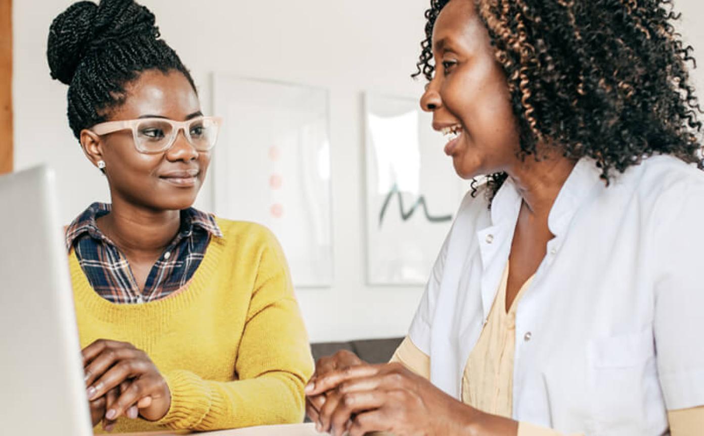 Health care provider with a laptop talking to a patient
