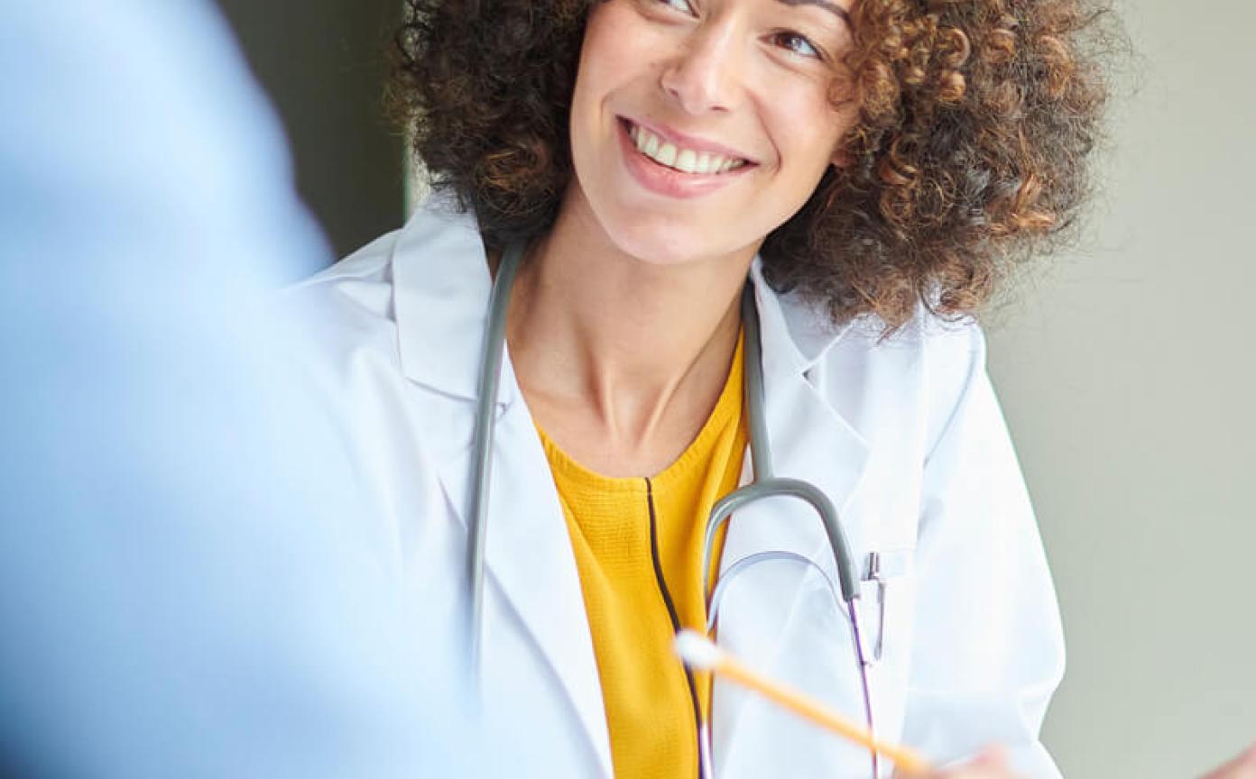 Health worker with a patient smiling and taking notes