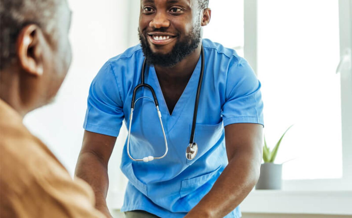 Health worker helping older person to stand up