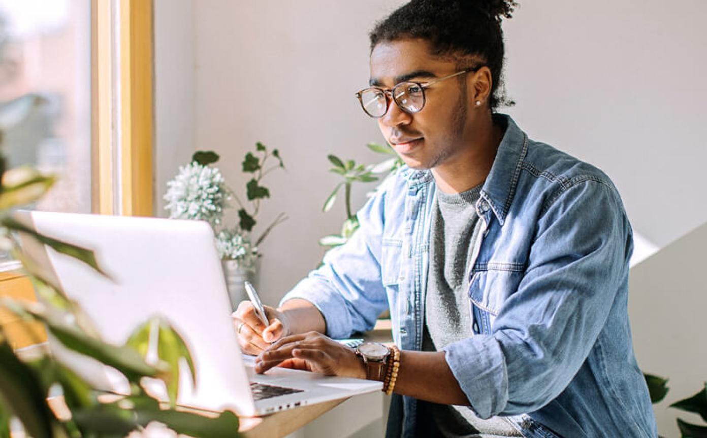 Person working with laptop in a room with plants