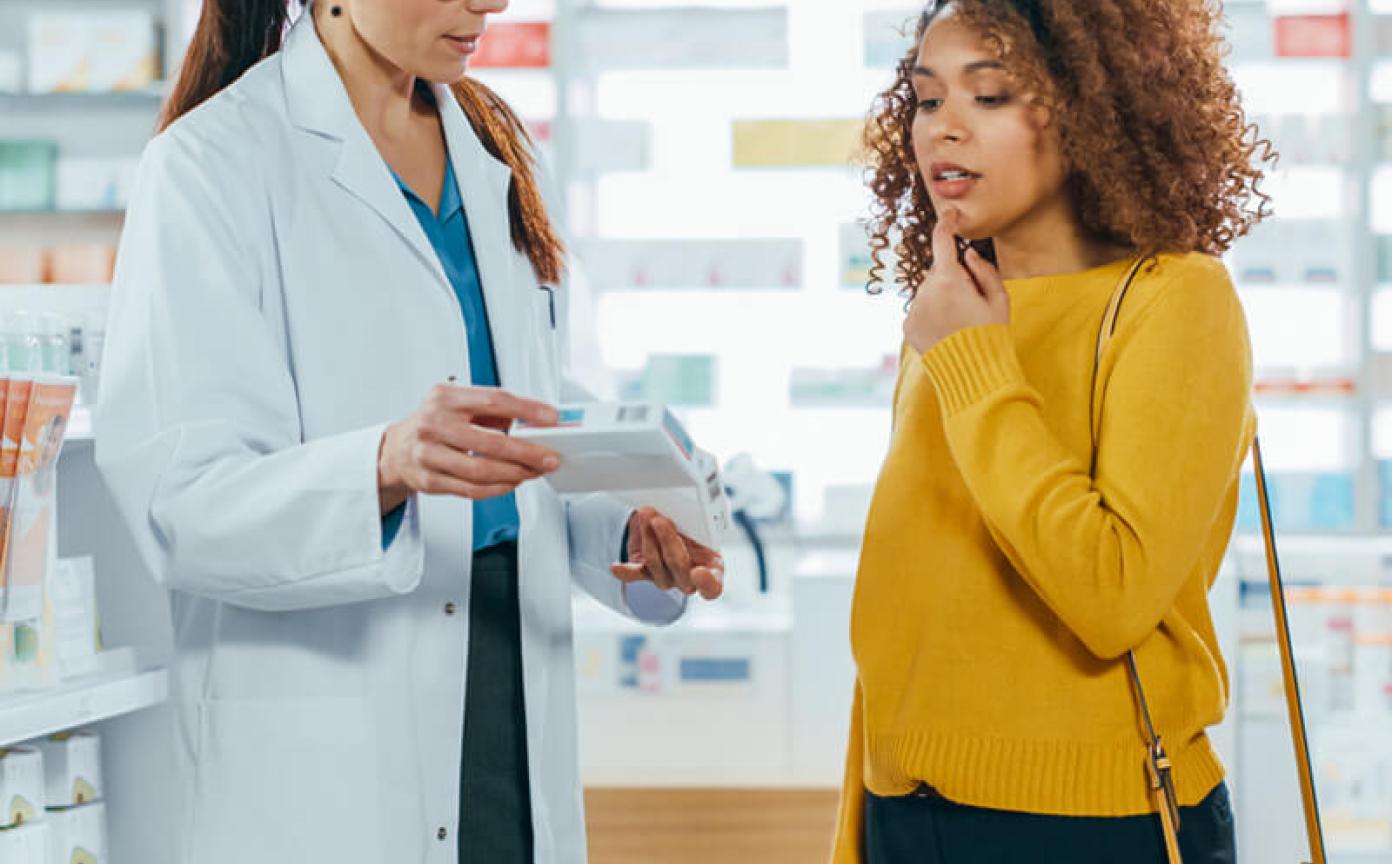 Pharmacist helping a patient who is thinking in a pharmacy