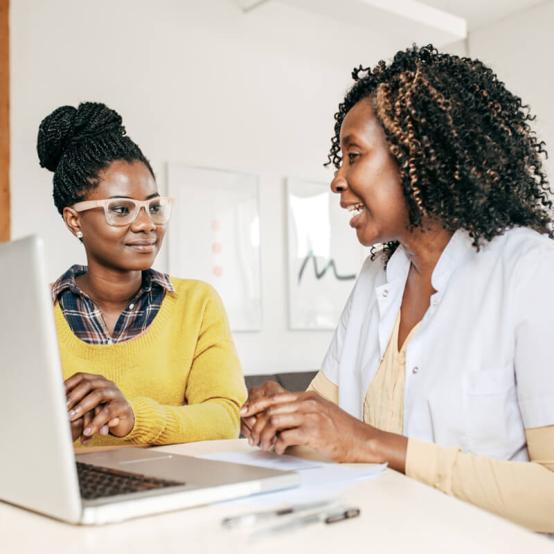 Health care provider with a laptop talking to a patient